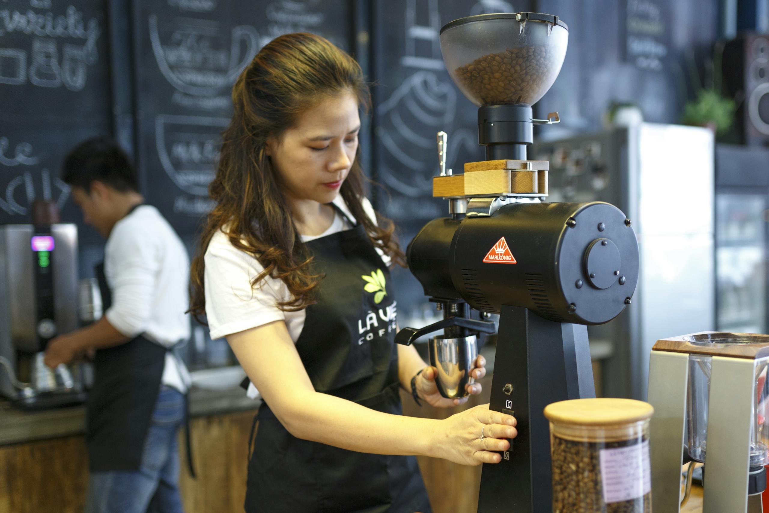 A barista making fresh coffee at a modern cafe, highlighting the coffee-making process.